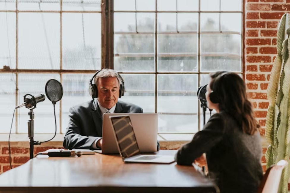 a senior businessman being interviewed by a female journalist in a studio