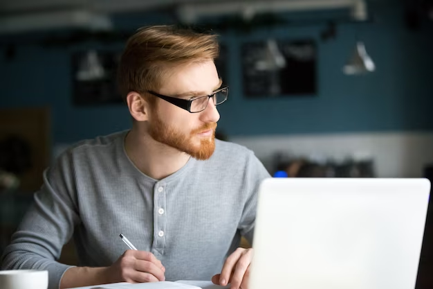 Thoughtful man thinking about new idea writing notes in cafe