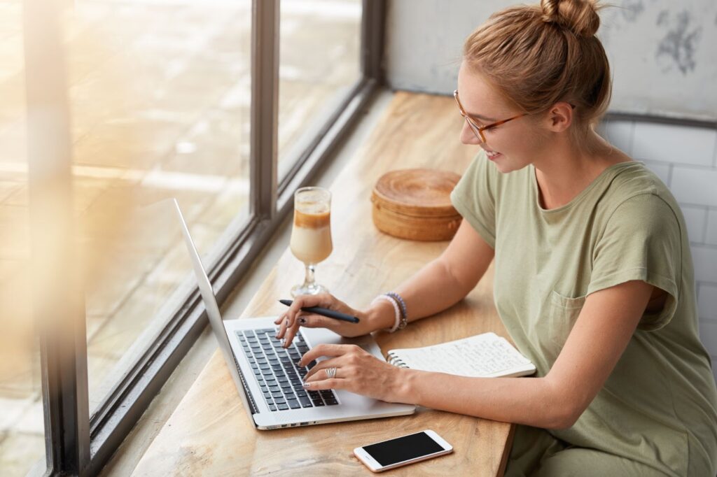 A woman works on her laptop in a cafe